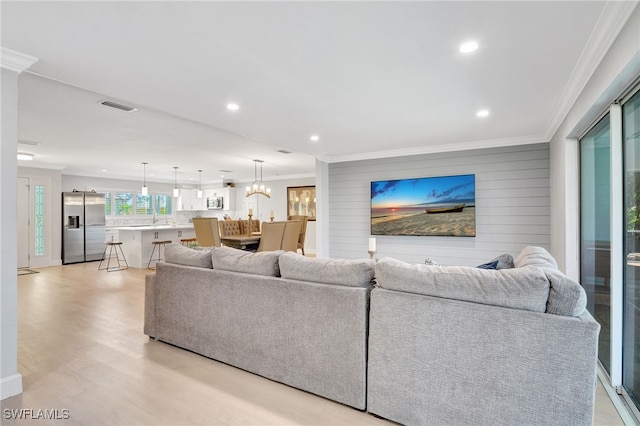 living room featuring ornamental molding, light wood-type flooring, and recessed lighting