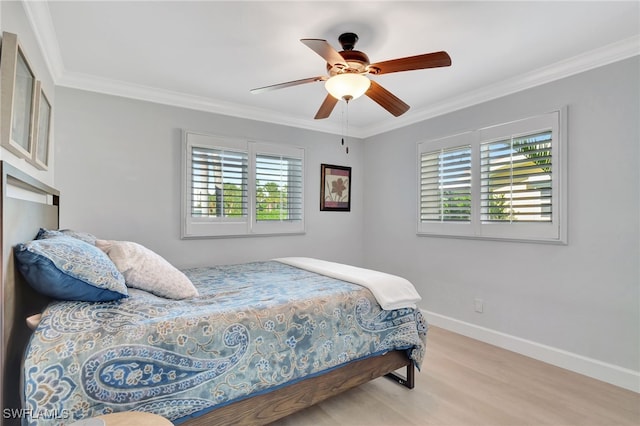 bedroom featuring light hardwood / wood-style flooring, ceiling fan, and ornamental molding