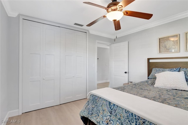 bedroom featuring a closet, light hardwood / wood-style flooring, ceiling fan, and ornamental molding