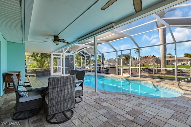 pool featuring a patio, ceiling fan, and glass enclosure