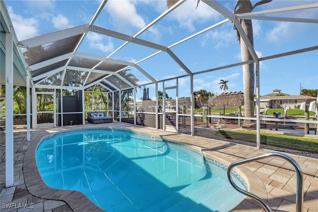 outdoor pool featuring a patio area and glass enclosure