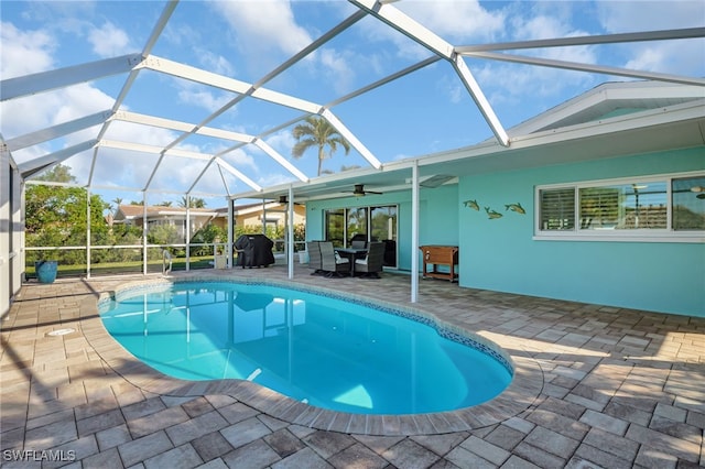 swimming pool featuring ceiling fan, a patio area, and glass enclosure