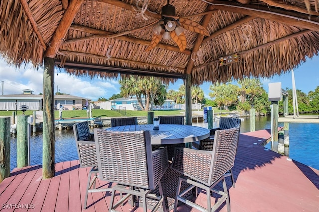 view of dock with a gazebo, boat lift, and a water view