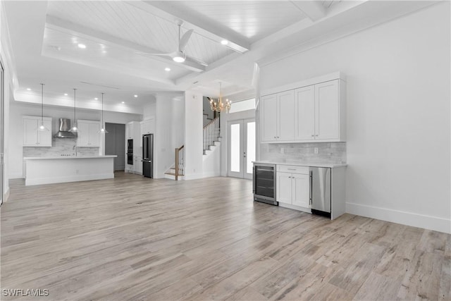 unfurnished living room with wooden ceiling, light hardwood / wood-style floors, beamed ceiling, beverage cooler, and ceiling fan with notable chandelier