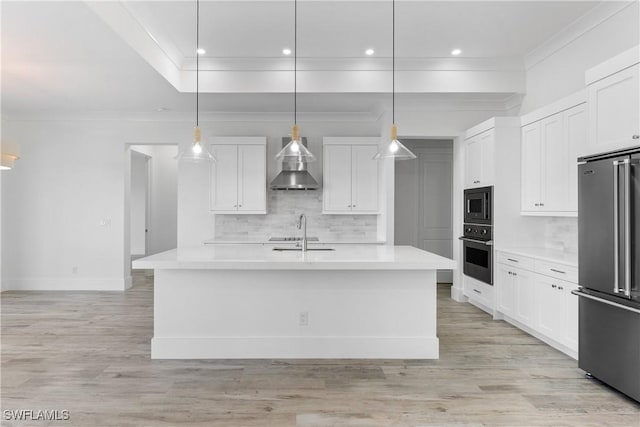 kitchen featuring pendant lighting, appliances with stainless steel finishes, an island with sink, and white cabinets