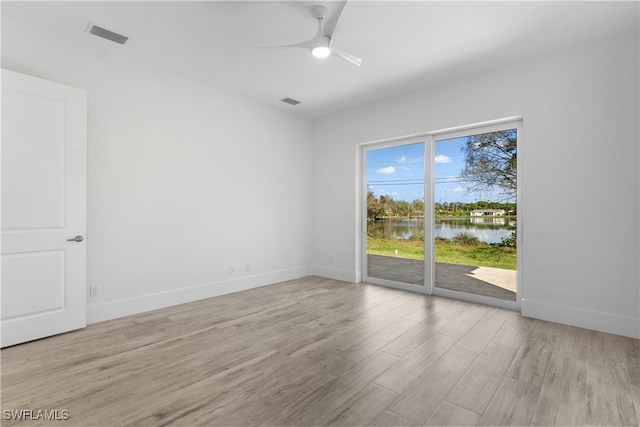 unfurnished room featuring a water view, ceiling fan, and light hardwood / wood-style flooring