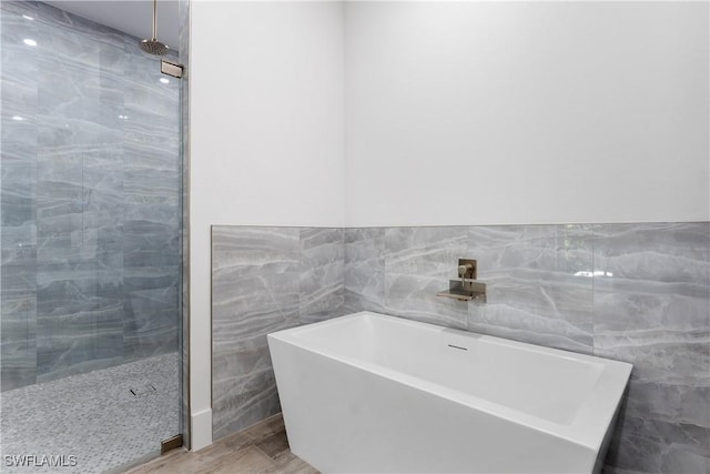 bathroom featuring hardwood / wood-style floors and plus walk in shower