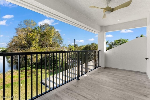 balcony featuring ceiling fan and a water view