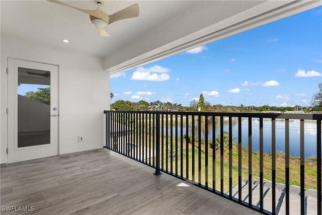 balcony featuring a water view and ceiling fan