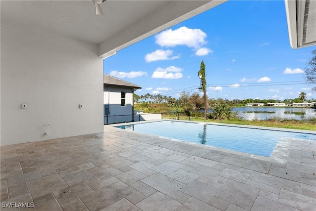 view of swimming pool featuring a water view, ceiling fan, and a patio area