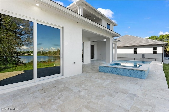 view of patio / terrace with an in ground hot tub and a water view