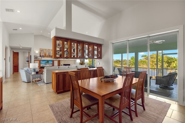 dining space featuring ceiling fan, light tile patterned floors, and high vaulted ceiling