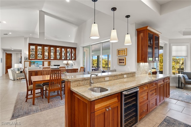 kitchen with sink, hanging light fixtures, tasteful backsplash, wine cooler, and lofted ceiling