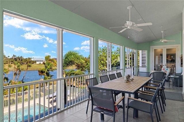 sunroom with ceiling fan, french doors, a water view, and lofted ceiling