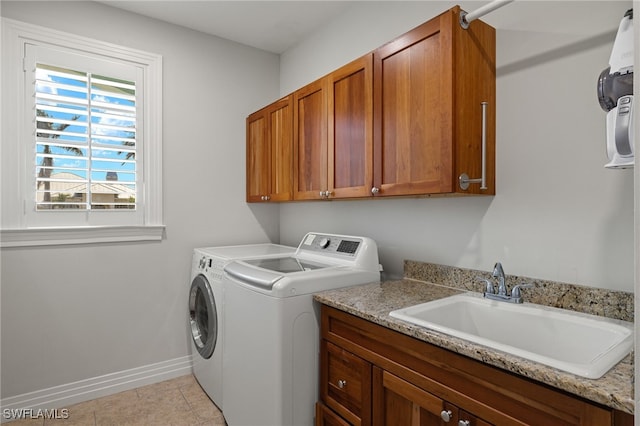 laundry area with washer and dryer, light tile patterned flooring, cabinets, and sink