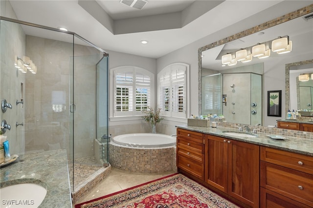 bathroom featuring tile patterned floors, a raised ceiling, vanity, and independent shower and bath