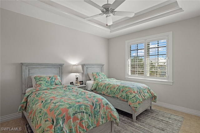 bedroom with ceiling fan and a raised ceiling