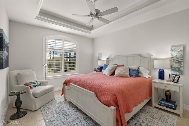 tiled bedroom featuring a tray ceiling and ceiling fan