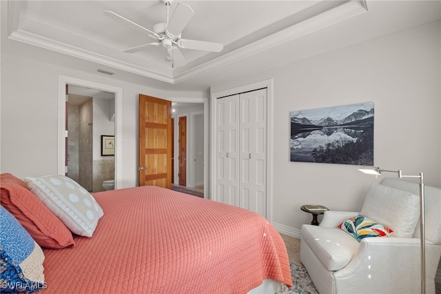 bedroom featuring a tray ceiling, a closet, ceiling fan, and crown molding