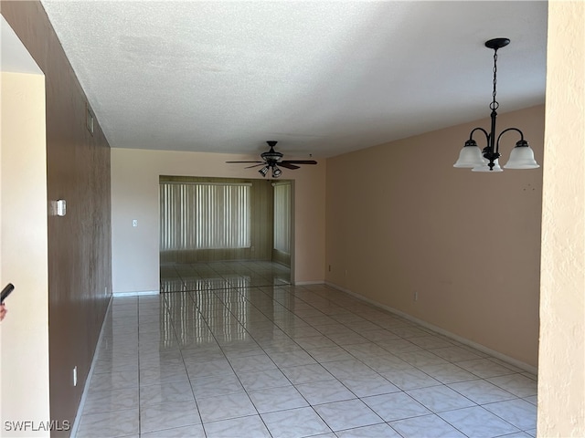 unfurnished room featuring a textured ceiling and ceiling fan with notable chandelier