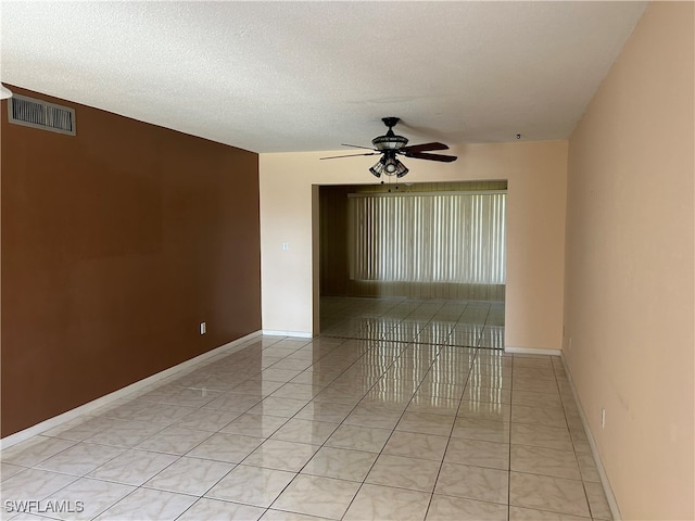 empty room with a textured ceiling and ceiling fan