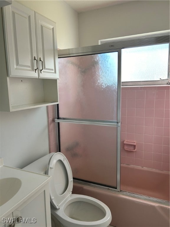 full bathroom with vanity, toilet, and bath / shower combo with glass door