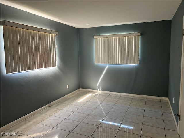 tiled spare room with a healthy amount of sunlight