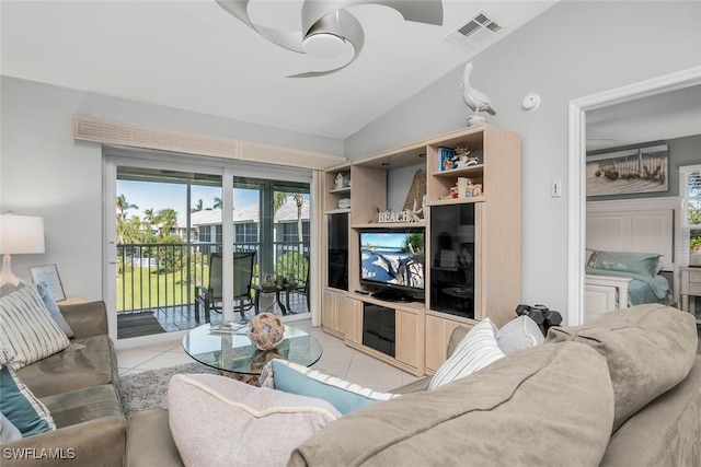 living room featuring ceiling fan, light tile patterned floors, and lofted ceiling