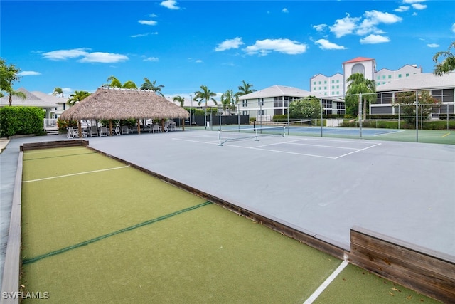 view of tennis court with basketball hoop