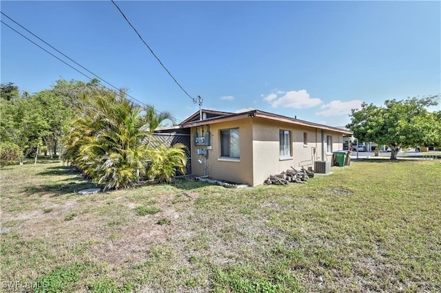 view of home's exterior featuring central AC unit and a lawn