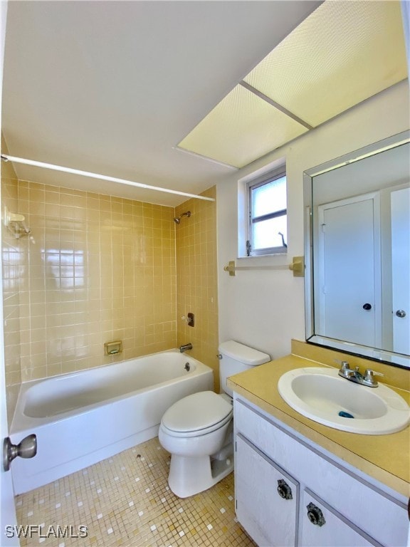 full bathroom with vanity, tiled shower / bath combo, tile patterned floors, and toilet