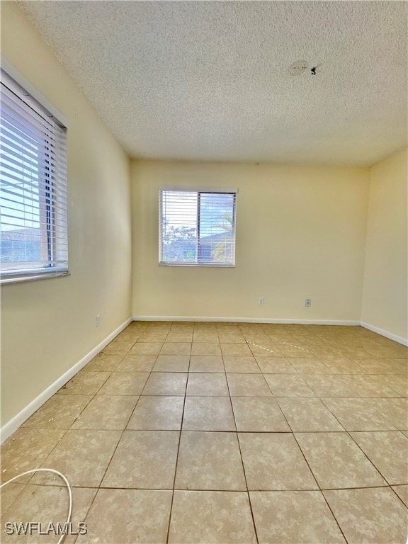 tiled spare room with a textured ceiling