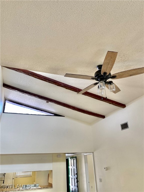 details with beamed ceiling, ceiling fan, and a textured ceiling