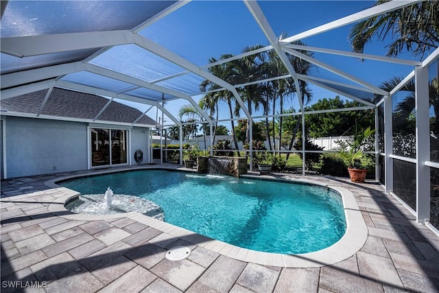 view of pool featuring pool water feature, glass enclosure, and a patio area