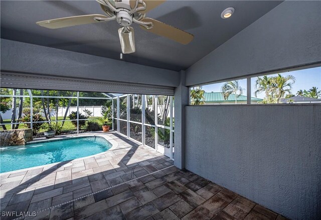 view of pool with pool water feature, ceiling fan, a lanai, and a patio