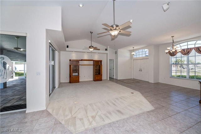 unfurnished living room with light tile patterned floors, ceiling fan with notable chandelier, and vaulted ceiling