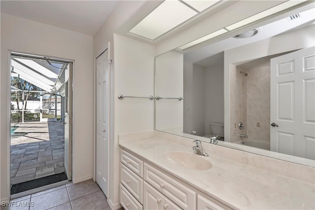 full bathroom featuring tile patterned floors, vanity, toilet, and tiled shower / bath combo