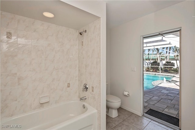 bathroom featuring toilet, tiled shower / bath combo, and tile patterned floors