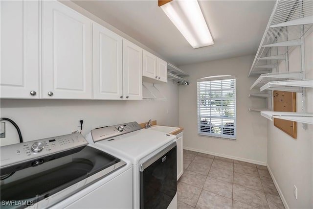 laundry room with cabinets, light tile patterned floors, separate washer and dryer, and sink