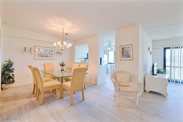 dining area with ceiling fan with notable chandelier, a textured ceiling, a wealth of natural light, and light hardwood / wood-style flooring