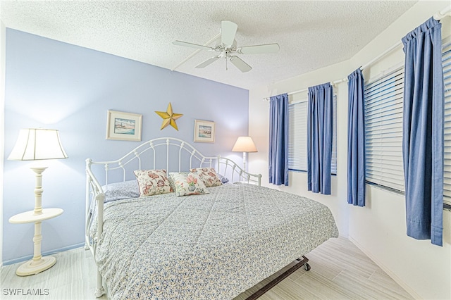 bedroom with ceiling fan and a textured ceiling