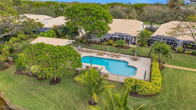 view of pool with glass enclosure and a yard