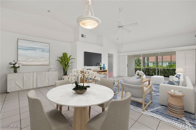 tiled dining space featuring ceiling fan and high vaulted ceiling