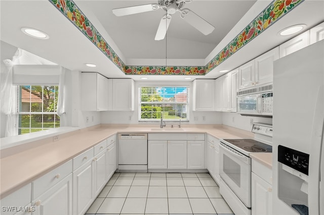 kitchen featuring white cabinetry, sink, vaulted ceiling, white appliances, and light tile patterned floors