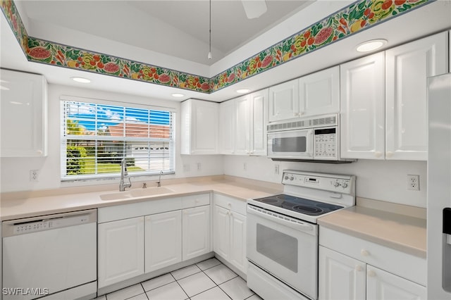 kitchen with white cabinetry, sink, vaulted ceiling, white appliances, and light tile patterned floors