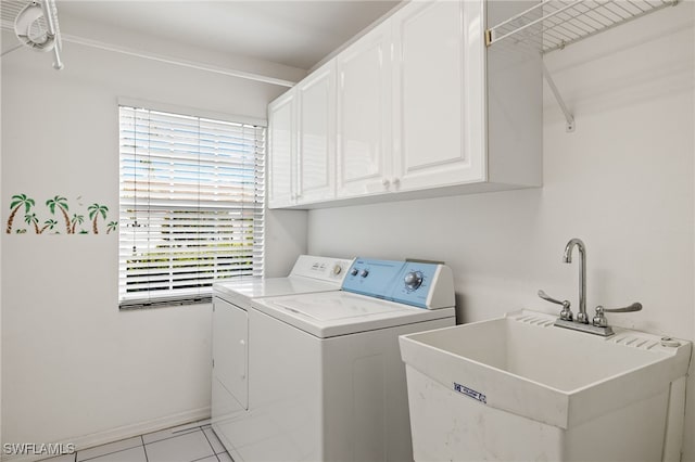 washroom with cabinets, light tile patterned floors, separate washer and dryer, and sink