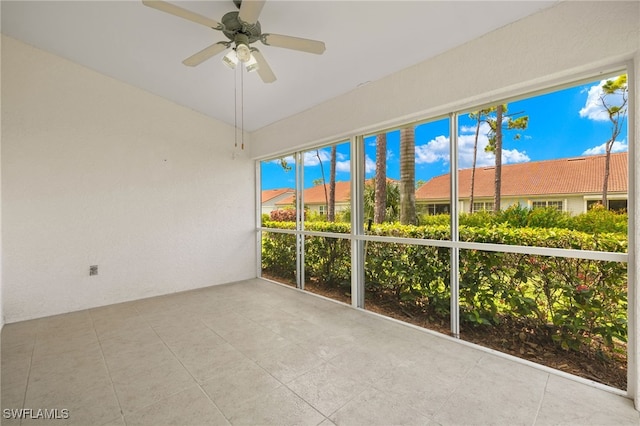 unfurnished sunroom featuring ceiling fan and a healthy amount of sunlight