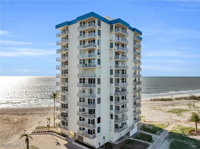 view of building exterior featuring a beach view and a water view