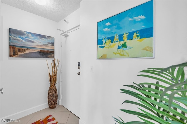 corridor with light tile patterned floors and a textured ceiling