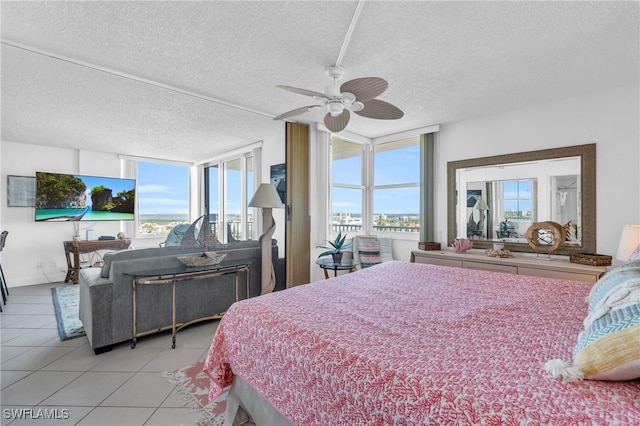 tiled bedroom featuring floor to ceiling windows, a textured ceiling, and ceiling fan